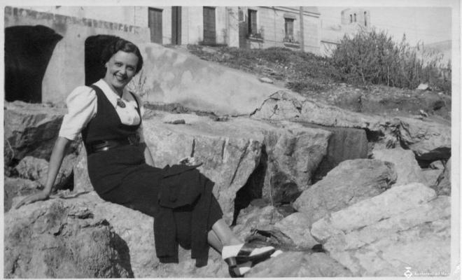 Ramona Torres asseguda a les roques de la vora del mar