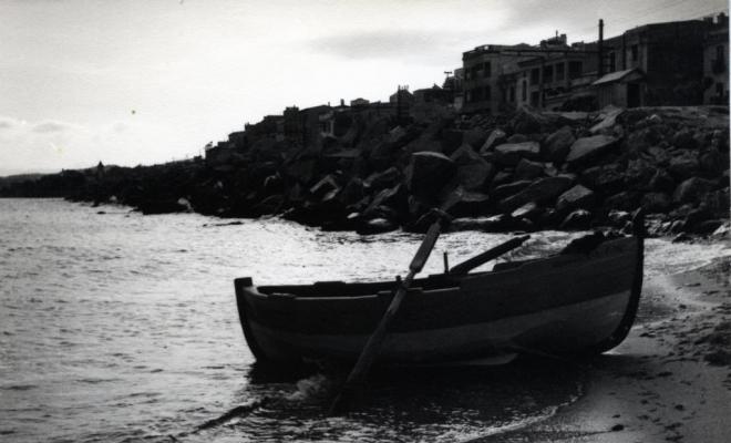 Barca de pesca de rems varada a la vora de la platja