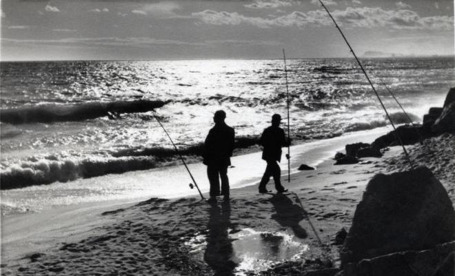 Dos homes pescant amb canya a la platja del Masnou