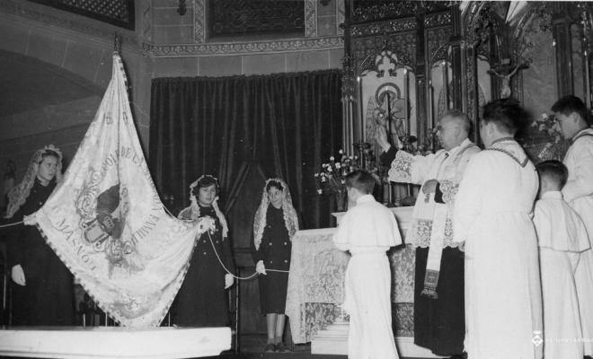 Mossèn Pere Clot beneïnt la bandera de la Sagrada Família el dia de Corpus