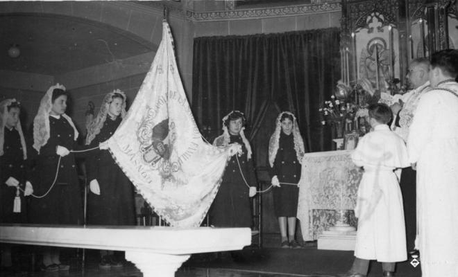 Mossèn Pere Clot beneïnt la bandera de la Sagrada Família el dia de Corpus