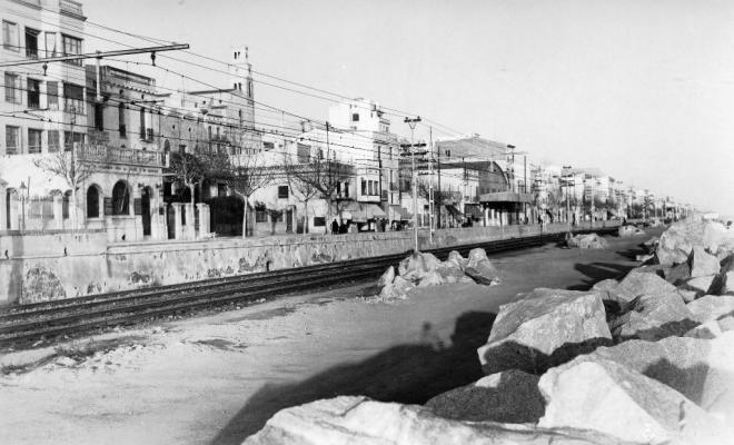 Vies de tren i façana marítima del Masnou des d'unes roques de la platja