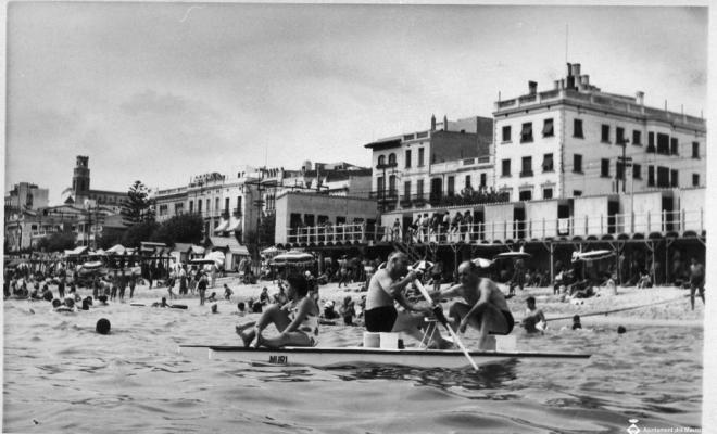 Banyistes remant en un patí davant la platja del Masnou