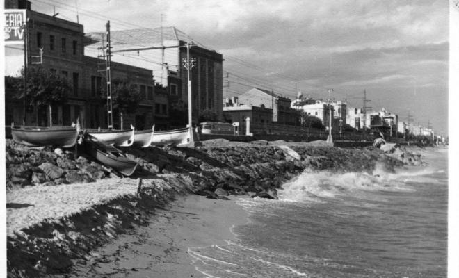 Onades trencant a la platja i les roques de la costa