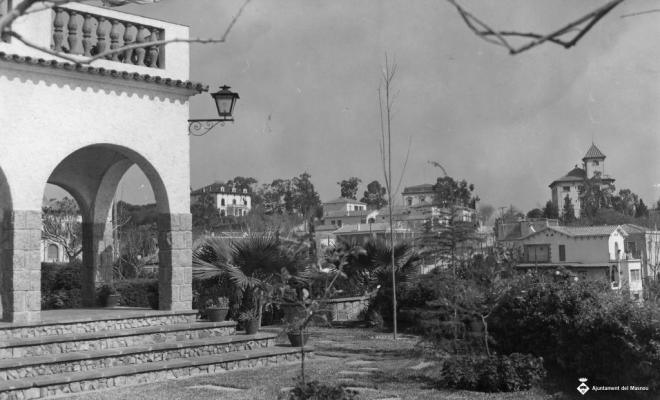 Vista de l'Alberg i altres cases des d'un jardí