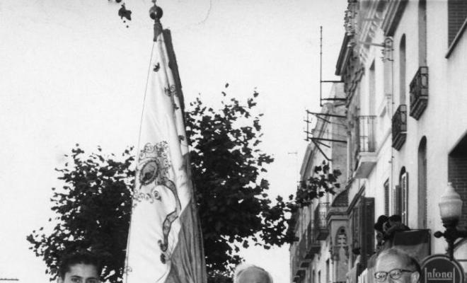 Tres homes amb una bandera durant la processó de Corpus