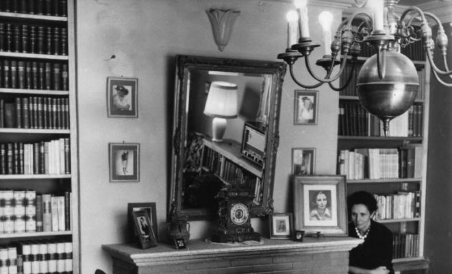 Retrat d'una dona al costat d'una llar de foc a la sala d'estar d'una casa