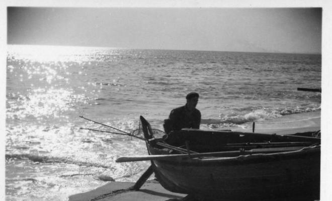 Pescador varant una barca de rems a la platja del Masnou