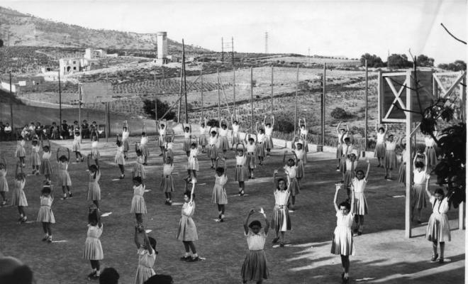 Grup de noies fent exercicis gimnàstics a l'aire lliure
