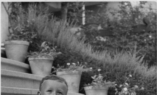 Infant assegut a unes escales amb un timbal als peus