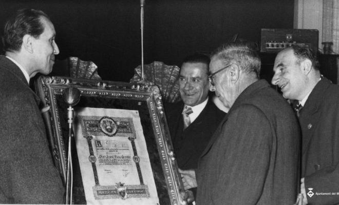 L'alcalde Salazar i altres homes lliurant un títol la Calàndria a favor de Josep Puig Godàs