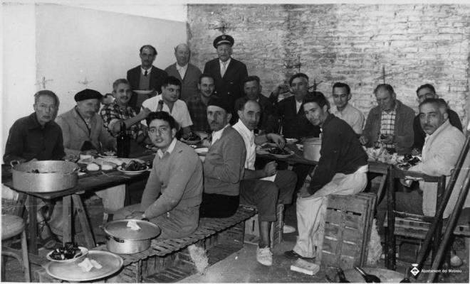 Grup d'homes dinant a la plaça del Mercat Vell