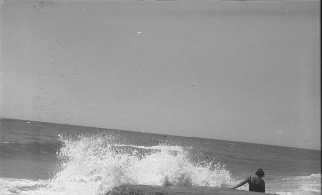 Dona en una roca a la platja
