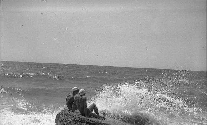 Dos banyistes en una roca a la platja