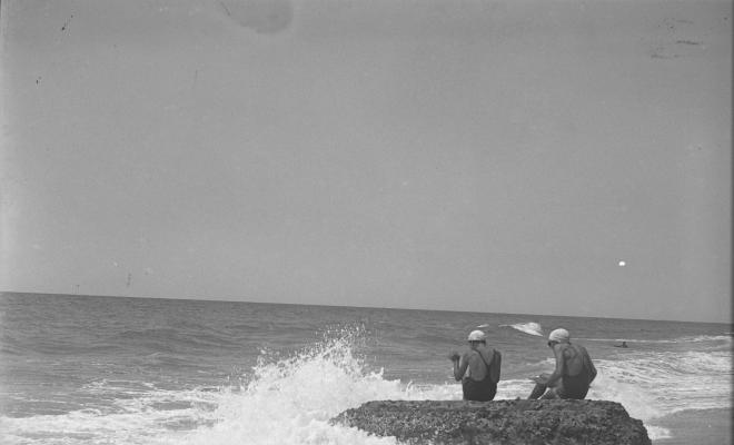 Dos banyistes en una roca a la platja