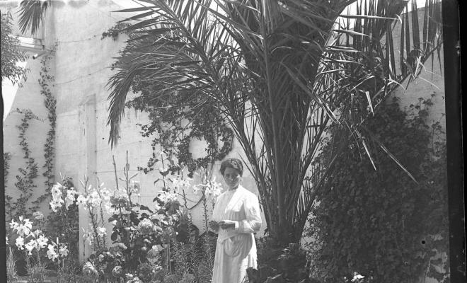 Retrat d'una dona al jardí d'una casa