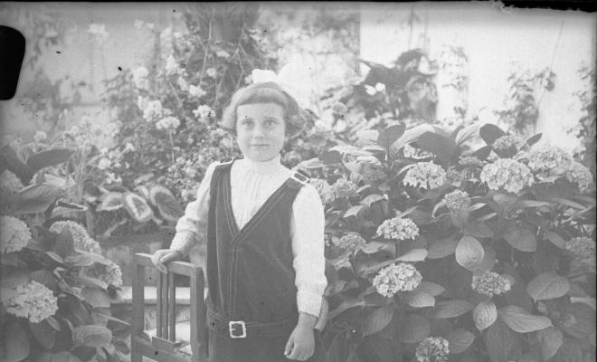 Retrat d'una nena en un jardí particular