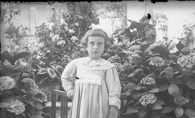 Retrat d'una nena en un jardí particular