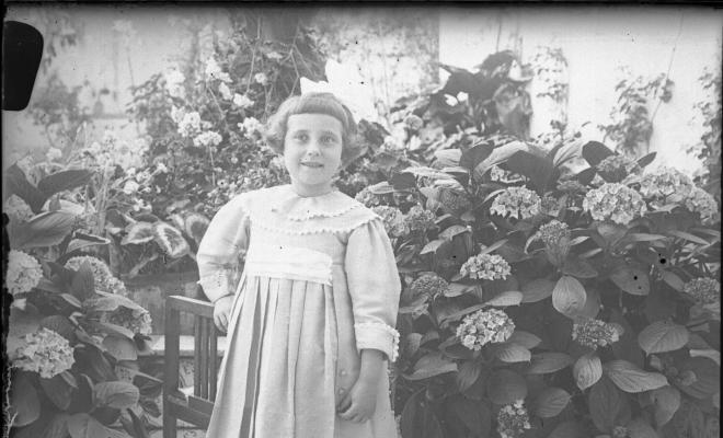 Retrat d'una nena en un jardí particular