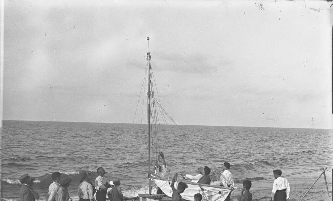 Patí de vela varat a la sorra de la platja