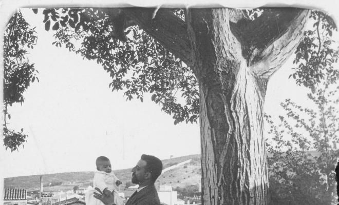 Retrat d'un home amb nadó al costat d'un arbre
