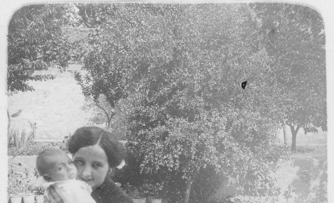 Retrat d'una dona amb un nadó en un jardí