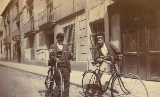 Dos homes amb bicicletes a un carrer de Barcelona
