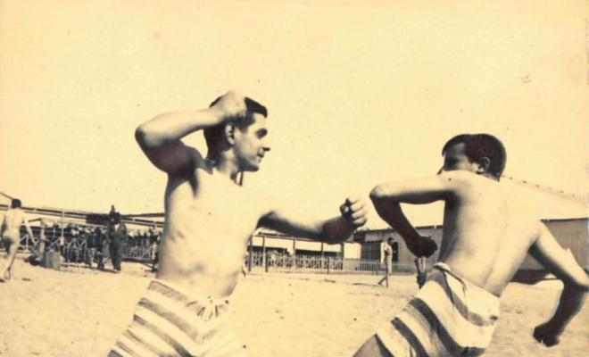 Dos homes jugant a la lluita a la platja