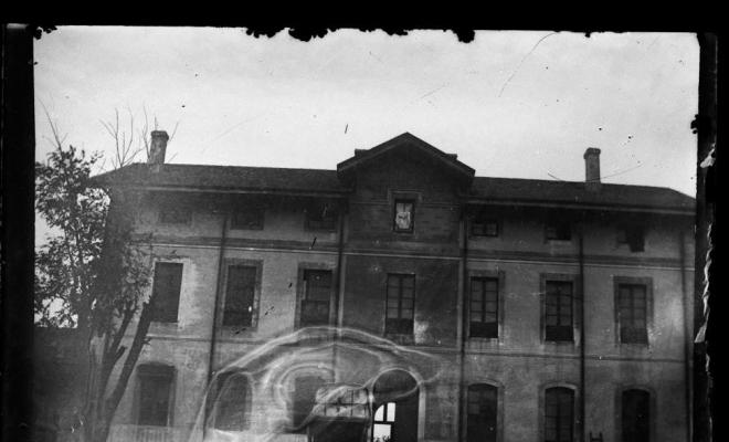 Exterior d'una casa, davant la qual hi ha un carro
