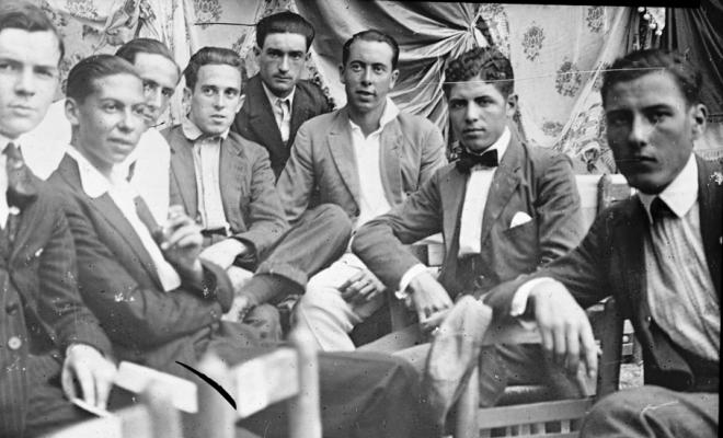 Un grup de nois asseguts a l'envelat
