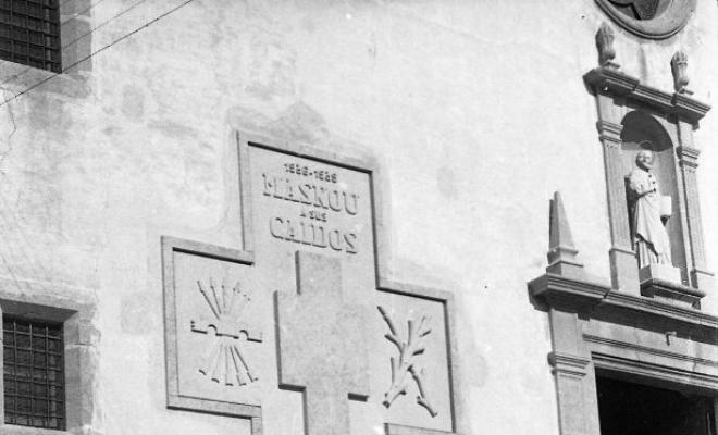 Creu del caiguts a la façana de l'església de Sant Pere