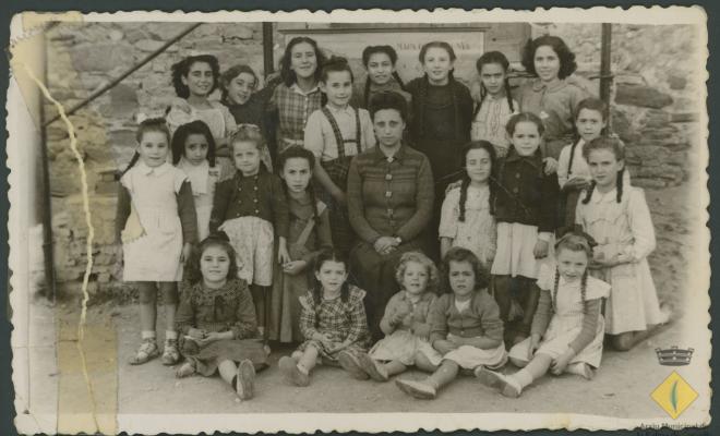 Grup escolar amb professora i alumnes nenes