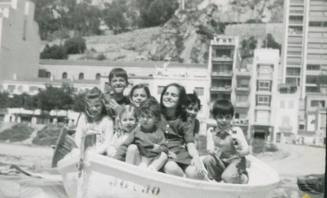 Infants en una barca a la vora del mar