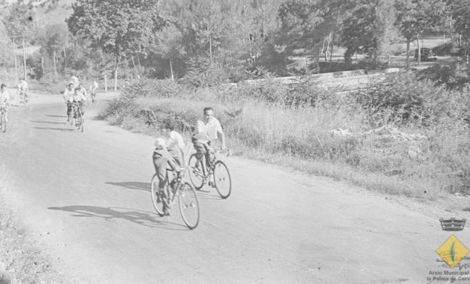 Grup de joves en bicicleta per l'actual carretera BV-2421 el dia de la visita del bisbe de Barcelona