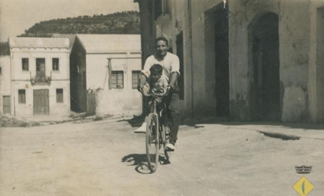 Miquel Aguilar amb el seu fill Àngel Aguilar en una bicicleta al carrer Santa Maria