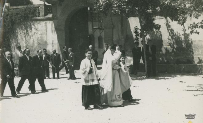 Mossèn i dos escolanets a la plaça de l'església