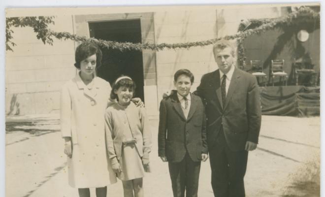 Els nens Rosa Maria Giberga i Josep Busquet Costabella amb els seus padrins, Rosa Albertí i Antonio Busquet, el dia de la seva confirmació, a la plaça de l'església decorada per la visita del bisbe Jubany