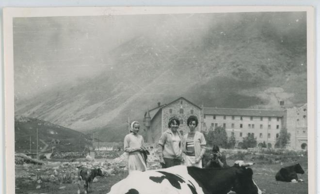 Tres dones davant una vaca frisona en una excursió a Núria