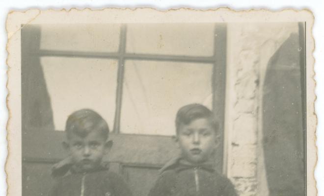 Els germans Casimiro Obiols i Quim Obiols davant la porta d'una casa