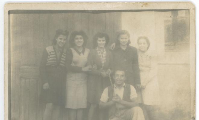 Retrat d'un grup de joves davant la porta de l'escola