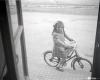 Elisabet Cabanas en bicicleta davant de la porta de la botiga de Cal Cabanas.