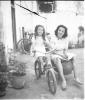 Retrat de l'Elisabet  Cabanas sobre una bicicleta i de la Maria Quiñonero asseguda sobre el sidecar de vímet.