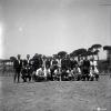 Activitats festives. Retrat dels components dels equips de futbol. Ubicació no identificada, a prop hi ha una catenària d'un tren.