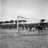 Activitats festives, partit de futbol. Ubicació no identificada, a prop hi ha una catenària d'un tren.