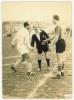 Dos jugadors es saluden al mig de l'antic camp de futbol de Montornès del Vallès davant de la presència de l'àrbitre del partit