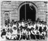 Grup de nens i nenes amb barretina davant l'Ajuntament