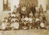Grup escolar femení davant de la porta de l'escola