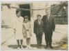 Els nens Rosa Maria Giberga i Josep Busquet Costabella amb els seus padrins, Rosa Albertí i Antonio Busquet, el dia de la seva confirmació, a la plaça de l'església decorada per la visita del bisbe Jubany